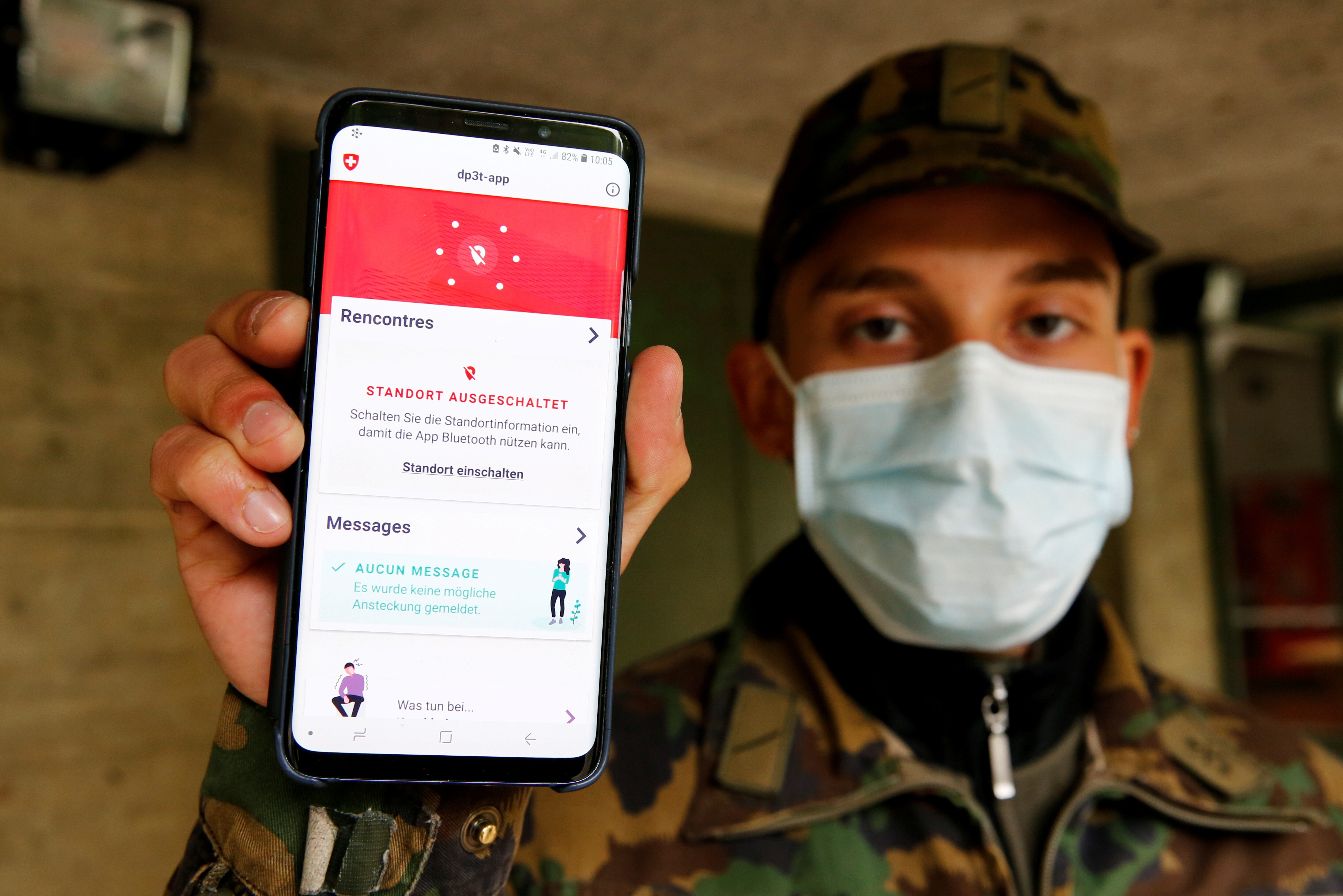 A Swiss soldier at the Chamblon barracks holds up a mobile device with the contact tracking application created by the Swiss Federal Institute of Technology Lausanne, using Bluetooth and a design called Decentralised Privacy-Preserving Proximity Tracing. Legislatures across Europe have debated how centralised their contact-tracing apps should be and how best to ensure data security. Photo: Reuters
