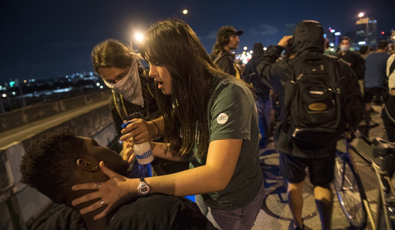 Protesters help others who have been affected by tear gas fired by New Orleans police. Photo: AP