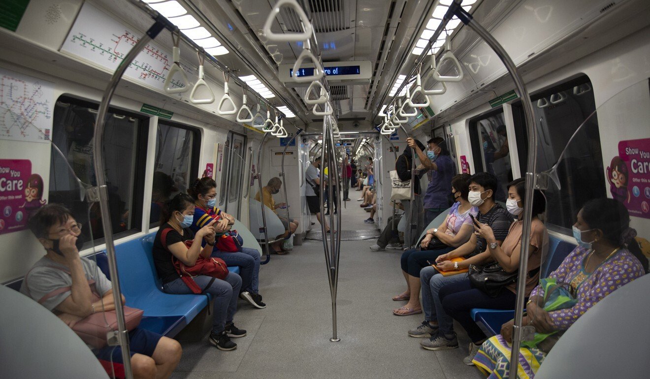 In Singapore, commuters wearing protective face masks on public transport. Photo: EPA