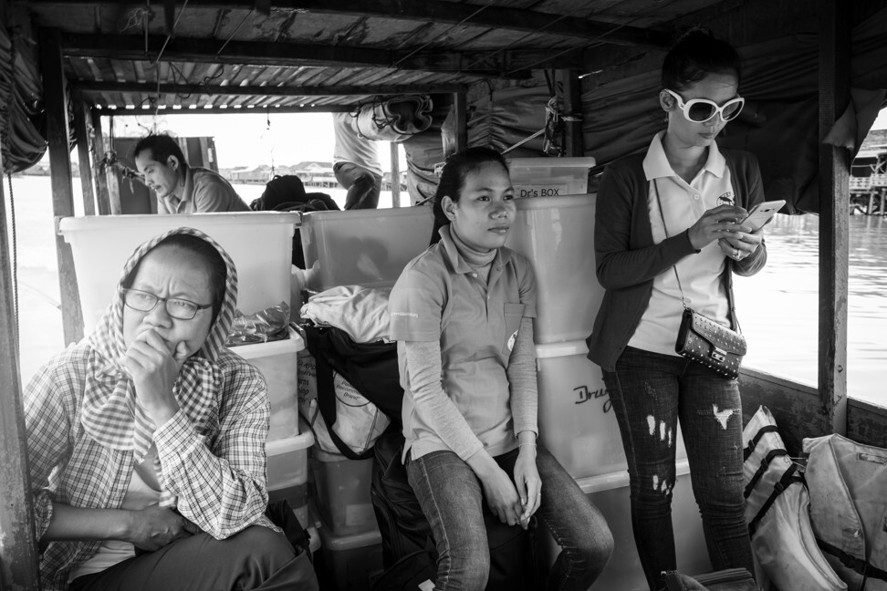 Midwives Ky Kolyan (left), Chan Soda (centre) and Chhuom Sary, and other members of TLC’s medical team cast off from the operation’s home port at Kampong Khleang. The team’s wooden boat heads for the floating clinic at Peam Bang, almost 50km to the south, where about 200 families live in poverty. Their journey to work will take more than four hours. Photo: Gary Jones