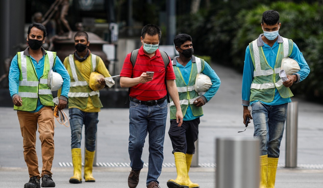 Migrant workers in essential services wearing safety vests in Singapore. Photo: Reuters