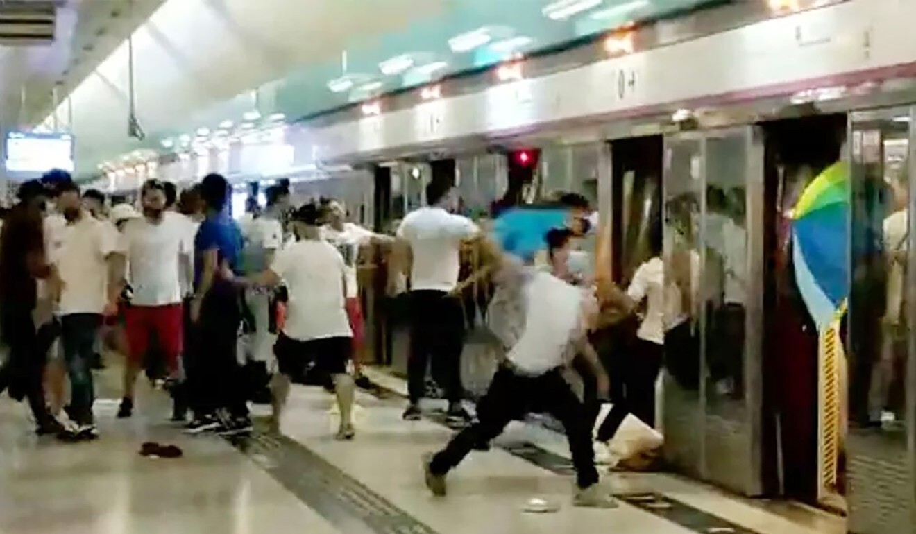People in white carrying wooden sticks chase passengers arriving at the Yuen Long MTR station on August 31 last year. Photo: SCMP Pictures