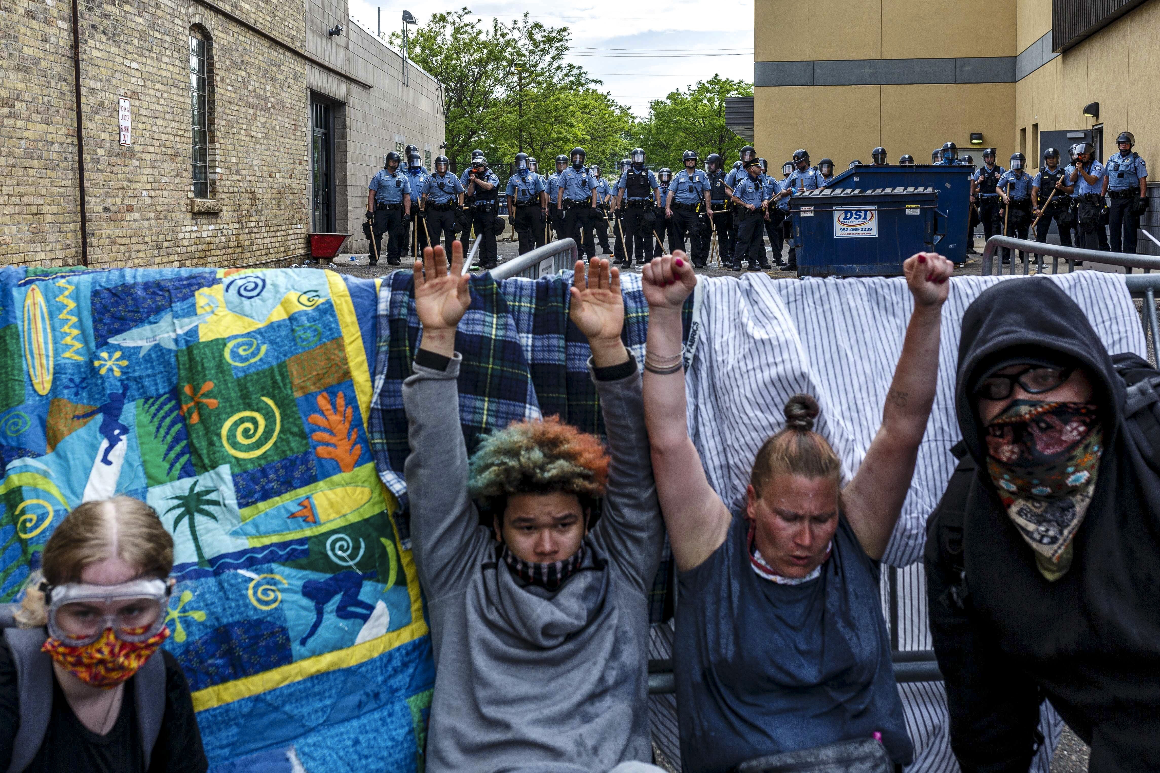 Protesters hold up their hands as they suffer the effects of tear gas during a George Floyd demonstration in Minneapolis, US, on May 27. Photo: AFP