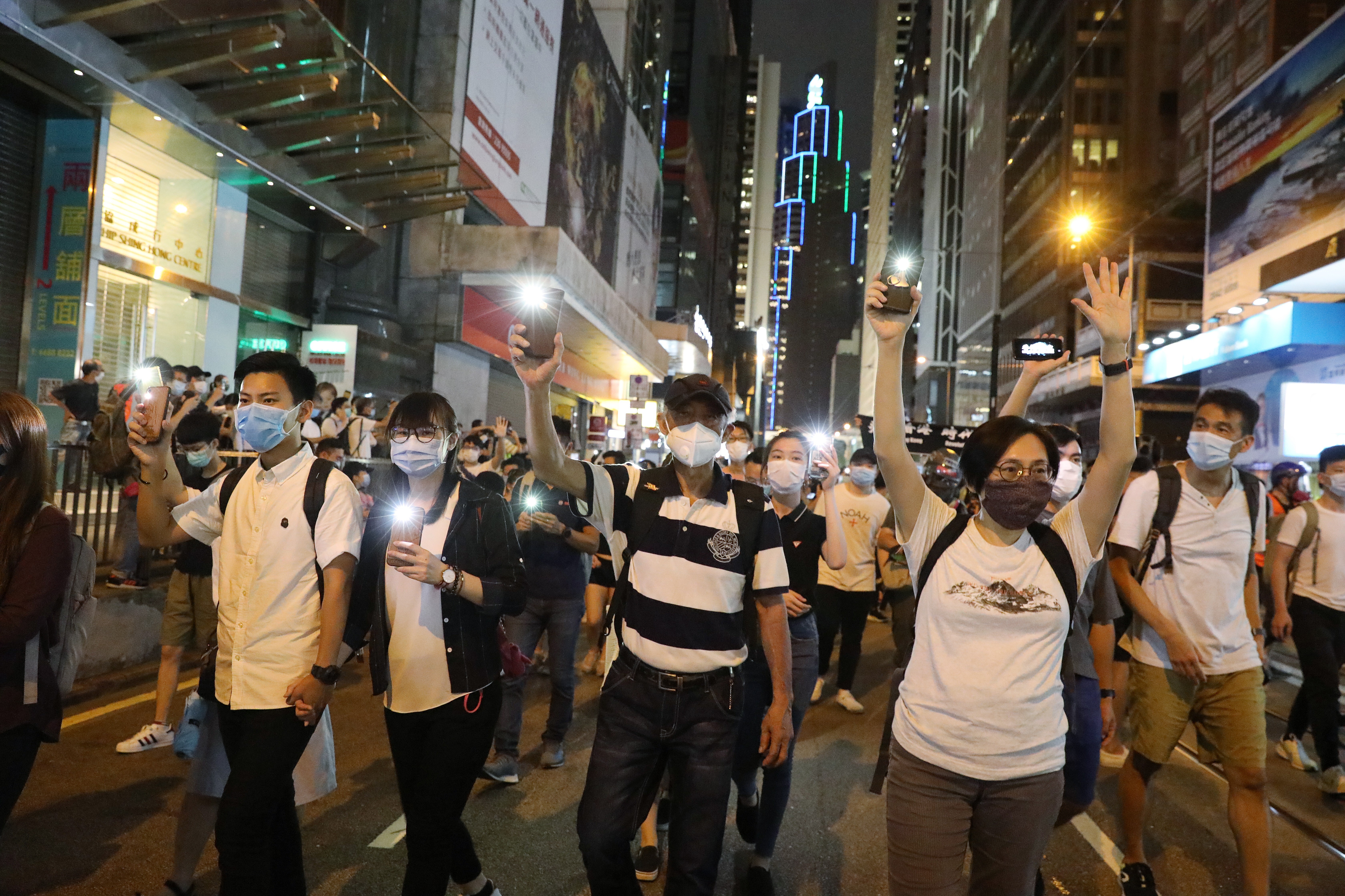 Demonstrators hold up their phones during a procession in Central on June 9 to mark the first anniversary of the protests against the Hong Kong government. Photo: Dickson Lee