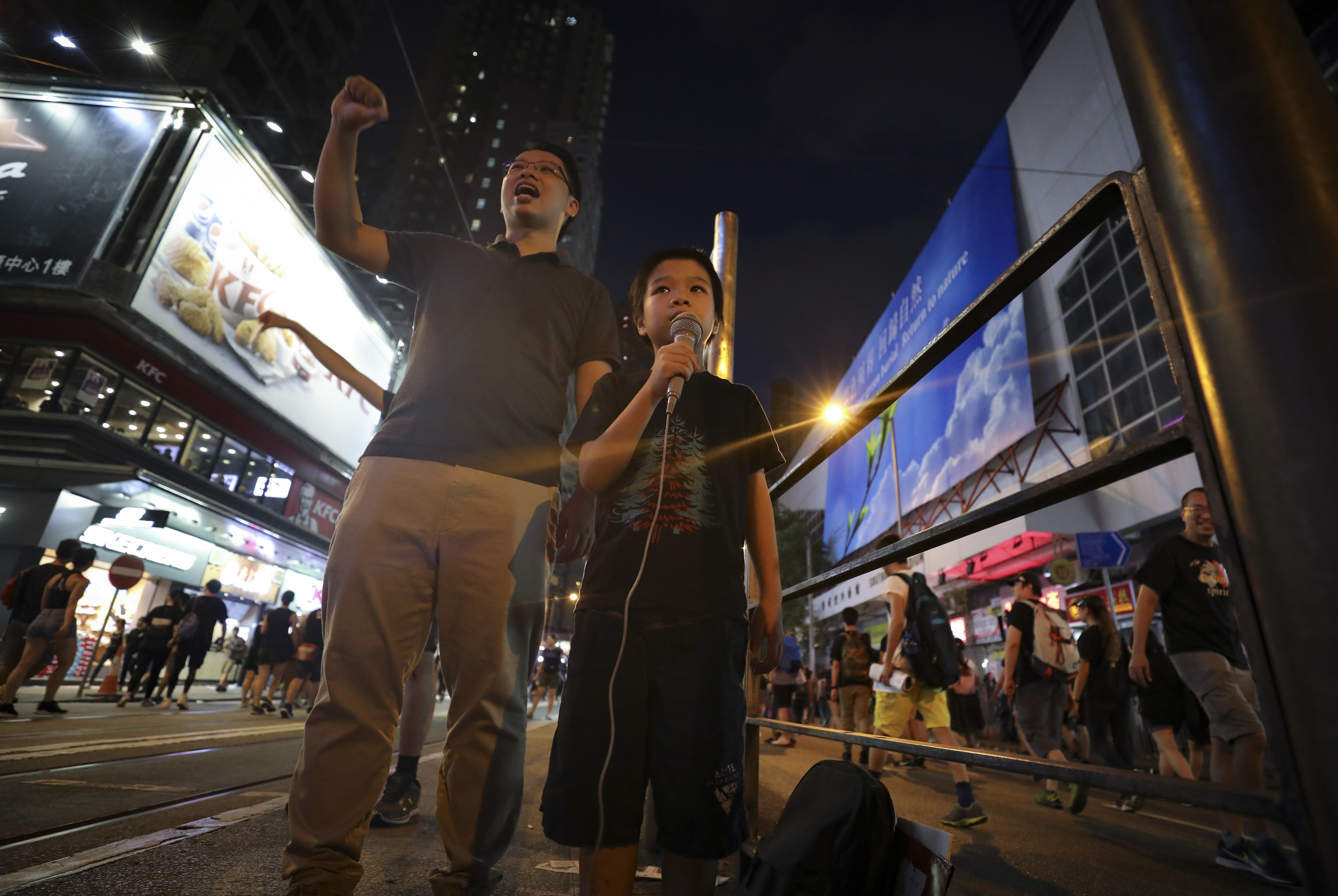 A father (left) and son chant slogans during a protest through Wan Chai in Hong Kong last year. There is a need for schools, parents and policymakers to work out how best to discuss the global protests in the classroom. Photo: James Wendlinger