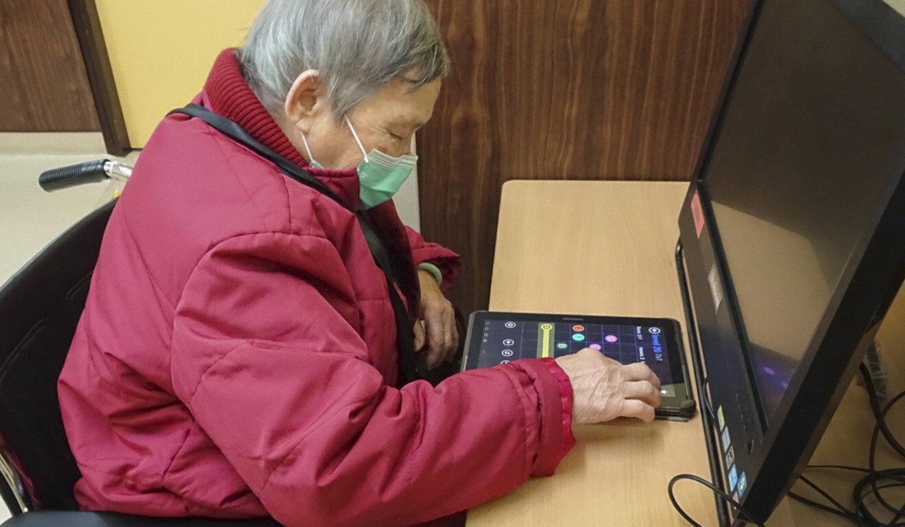 Chan Sim plays puzzle games on a tablet at her care home. Photo: Handout