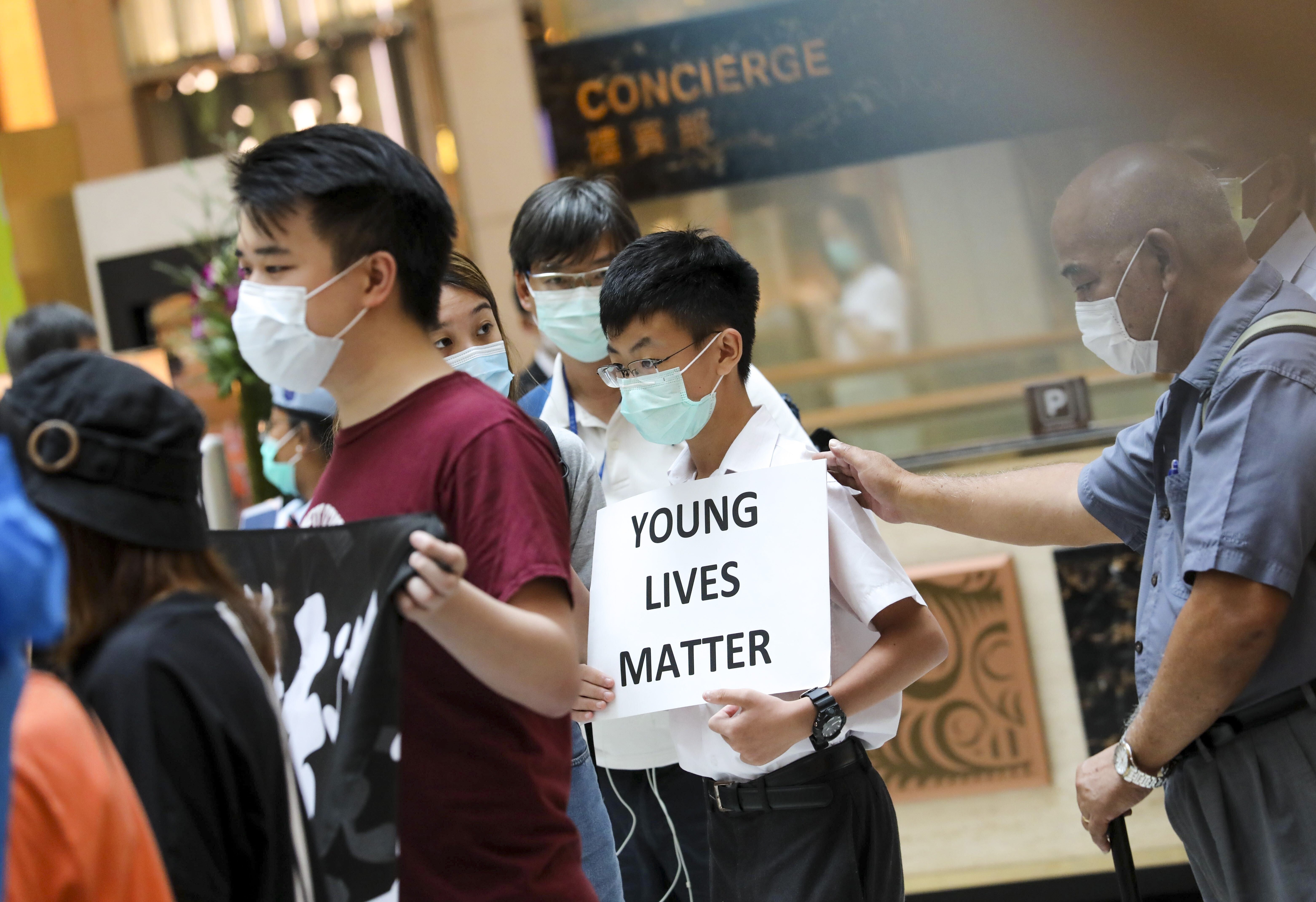 A teenager carries a placard saying “Young lives matter” at a lunchtime protest at the Landmark shopping centre in Central, Hong Kong. Photo: K.Y. Cheng