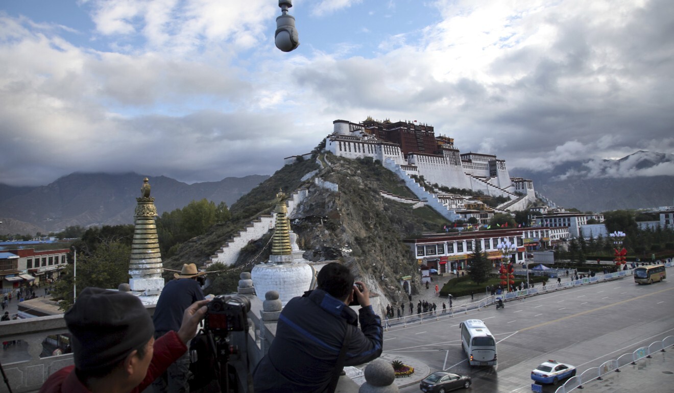 Tourists take photos of the Potala Palace beneath a security camera in Lhasa, capital of the Tibet Autonomous Region of China in this file picture. Photo: AP