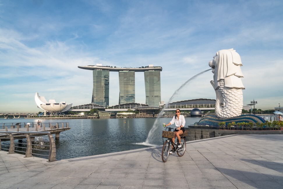A lone cyclist rides past Singapore’s Merlion Statue in the near-empty Merlion Park. After a period of partial lockdown known as the ‘circuit breaker’, Singapore began allowing more businesses to reopen on June 2. Photo: Bloomberg