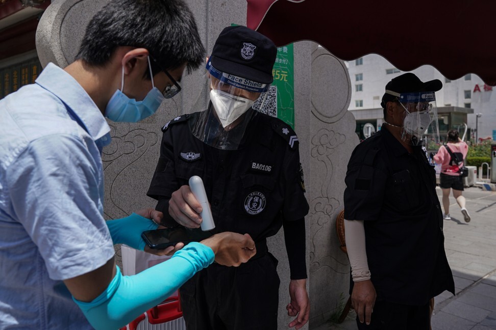 A security guard checks temperatures as people enter Youan Hospital for Covid-19 testing in Beijing on Monday. Beijing conducted more than 76,000 people on Monday. Photo: EPA-EFE