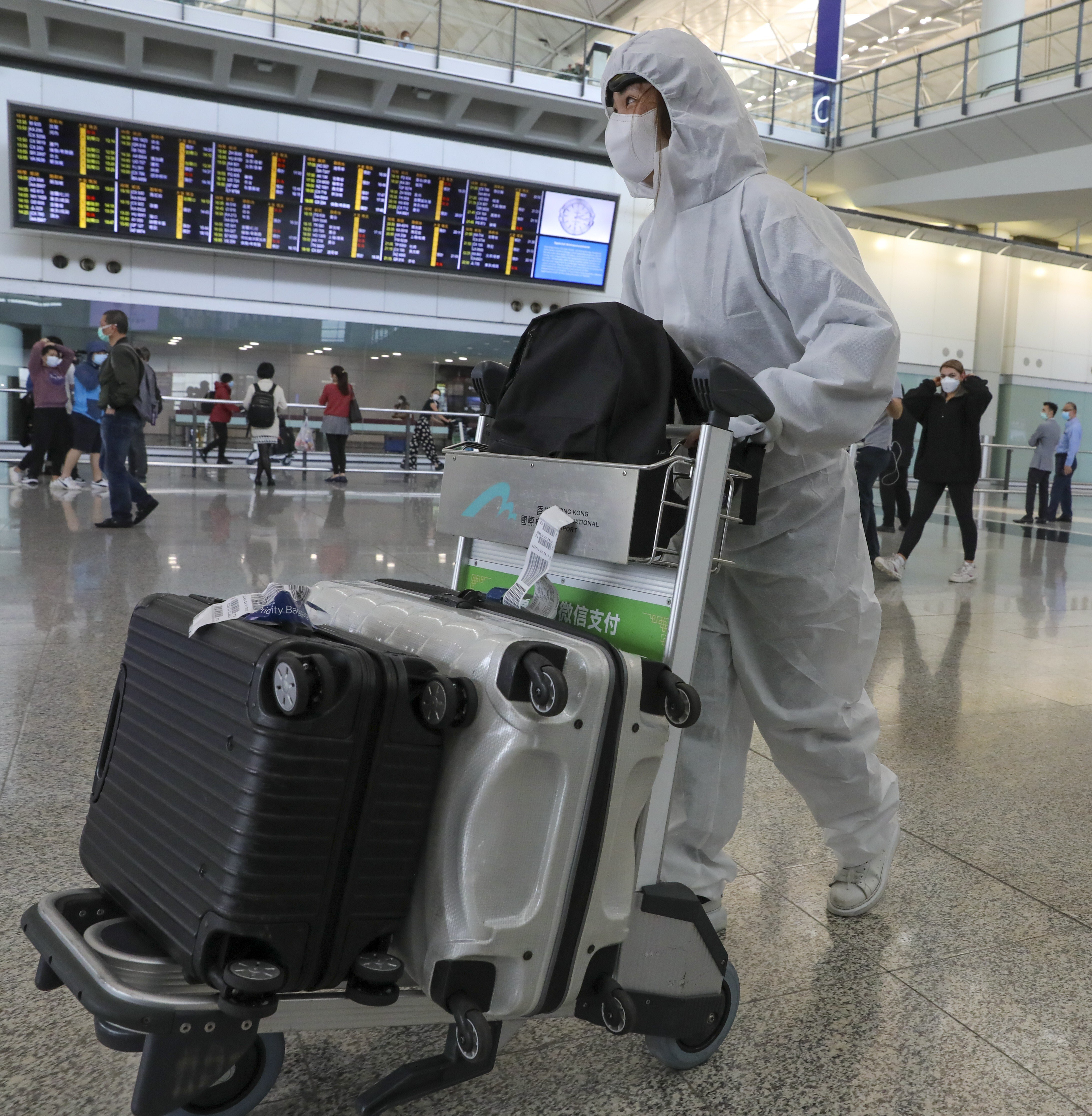 University student Amy Chan walks through Hong Kong International Airport on March 16 after returning from her studies in the United Kingdom amid the Covid-19 pandemic. Photo: K.Y. Cheng