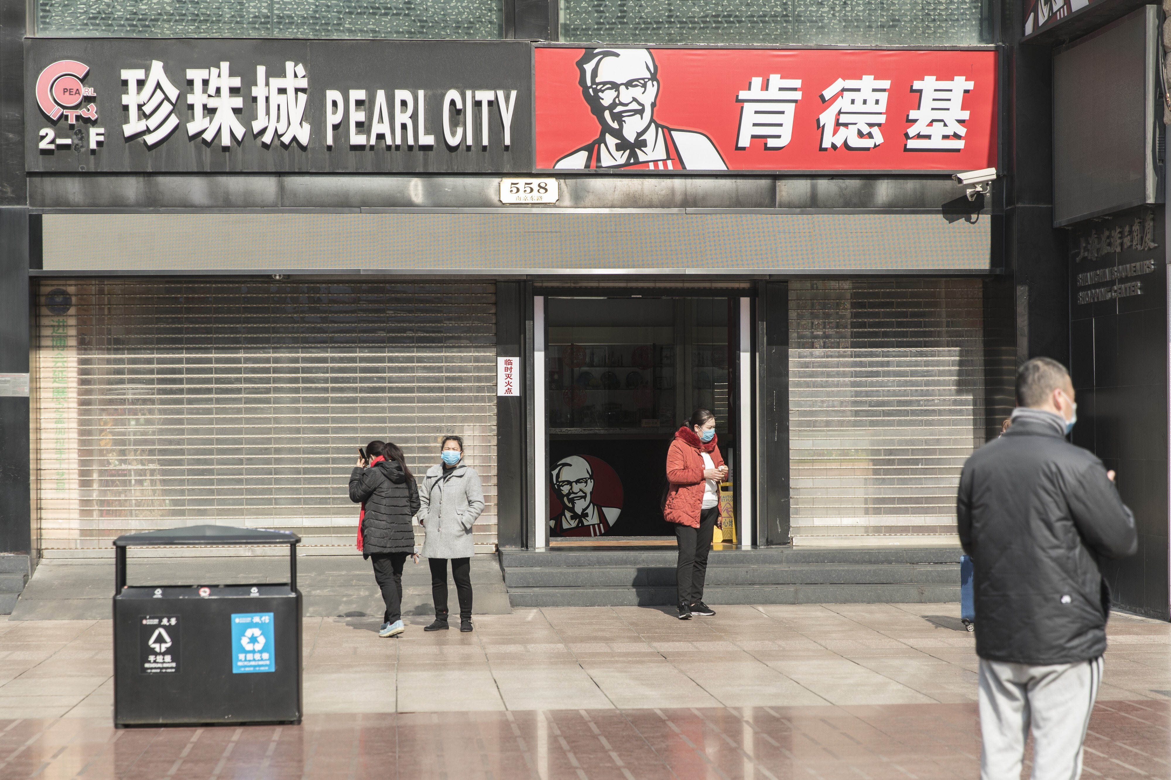 Pedestrians wearing protective masks stand in front of KFC restaurant on Nanjing Road in Shanghai, China, on February 5. Photo: Bloomberg