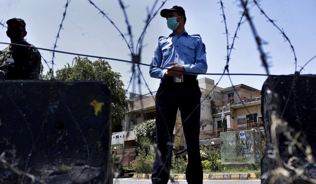 A police officer and paramilitary soldier stand guard at the checkpoint of a restricted area to help to contain the spread of new coronavirus in Islamabad, Pakistan on June 13. Photo: AP