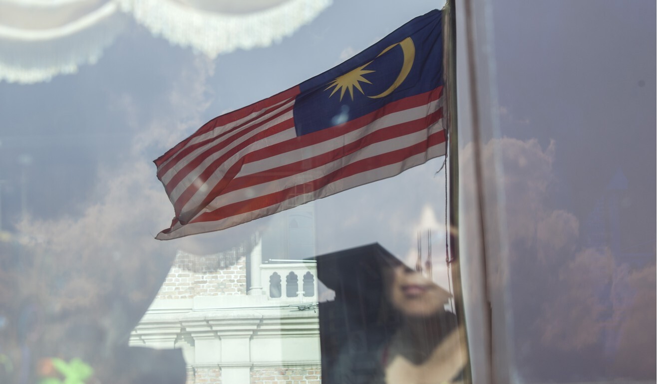 A Malaysian flag is reflected on bus window in Kuala Lumpur. Photo: Bloomberg