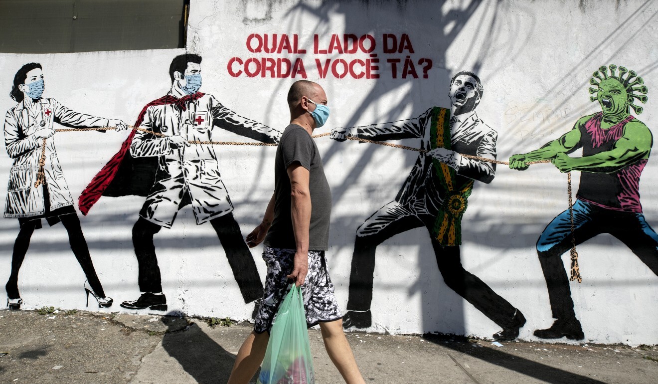 A mural in Sao Paulo depicts a tug of war between health workers and Brazil's President Jair Bolsonaro aided by a cartoon-style coronavirus character, with a message that reads in Portuguese: “Which side are you on?”. Photo: AP