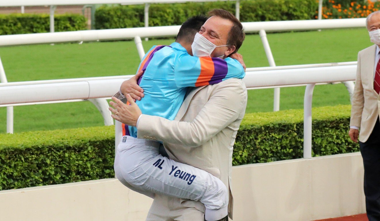 Jockey Keith Yeung and trainer Caspar Fownes embrace after Dances with Dragon’s victory.