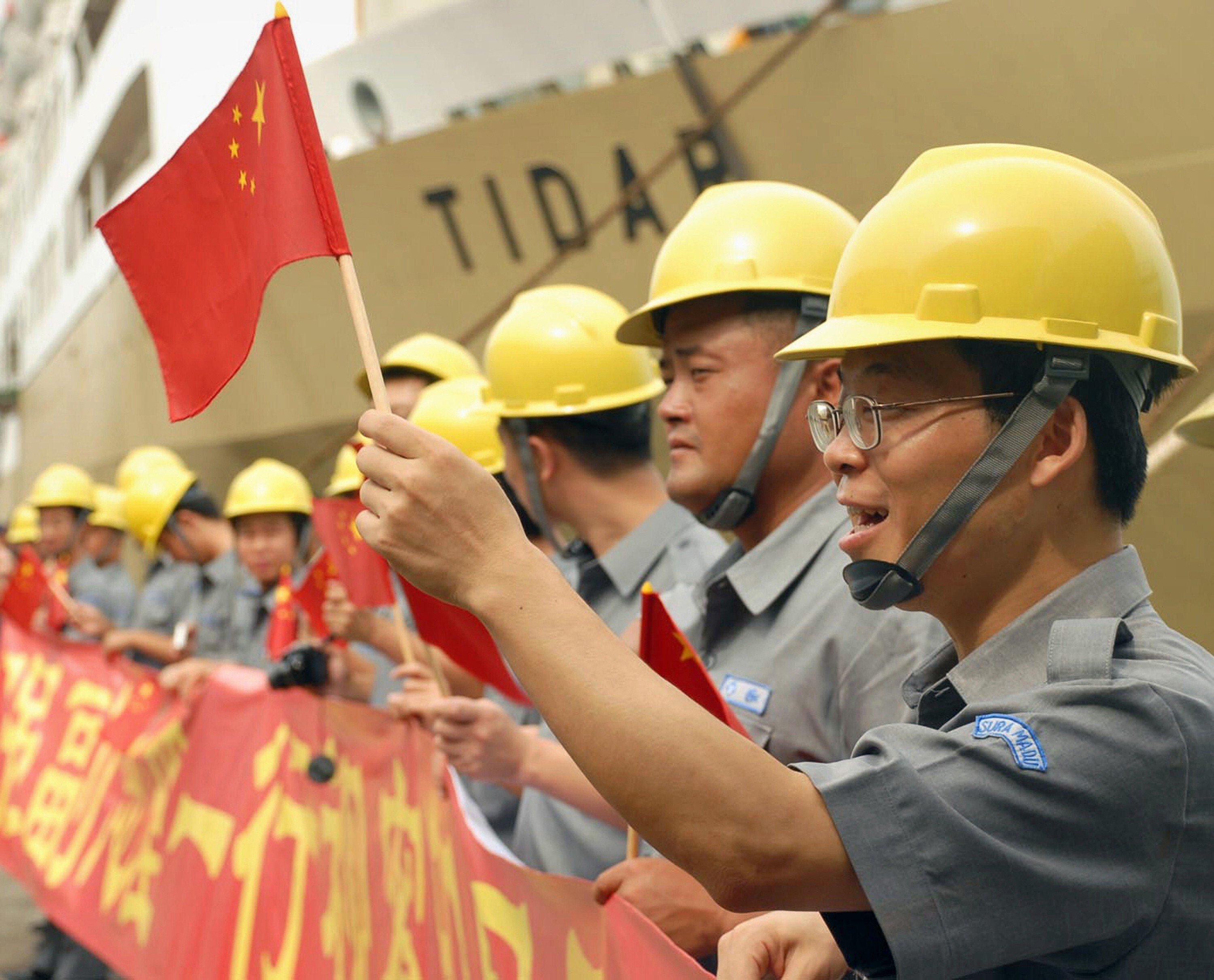Workers wave Chinese flags during China Vice-Premier Li Keqiang’s visit to the Suramadu bridge in Surabaya, East Java, on December 21, 2008. File photo: AFP
