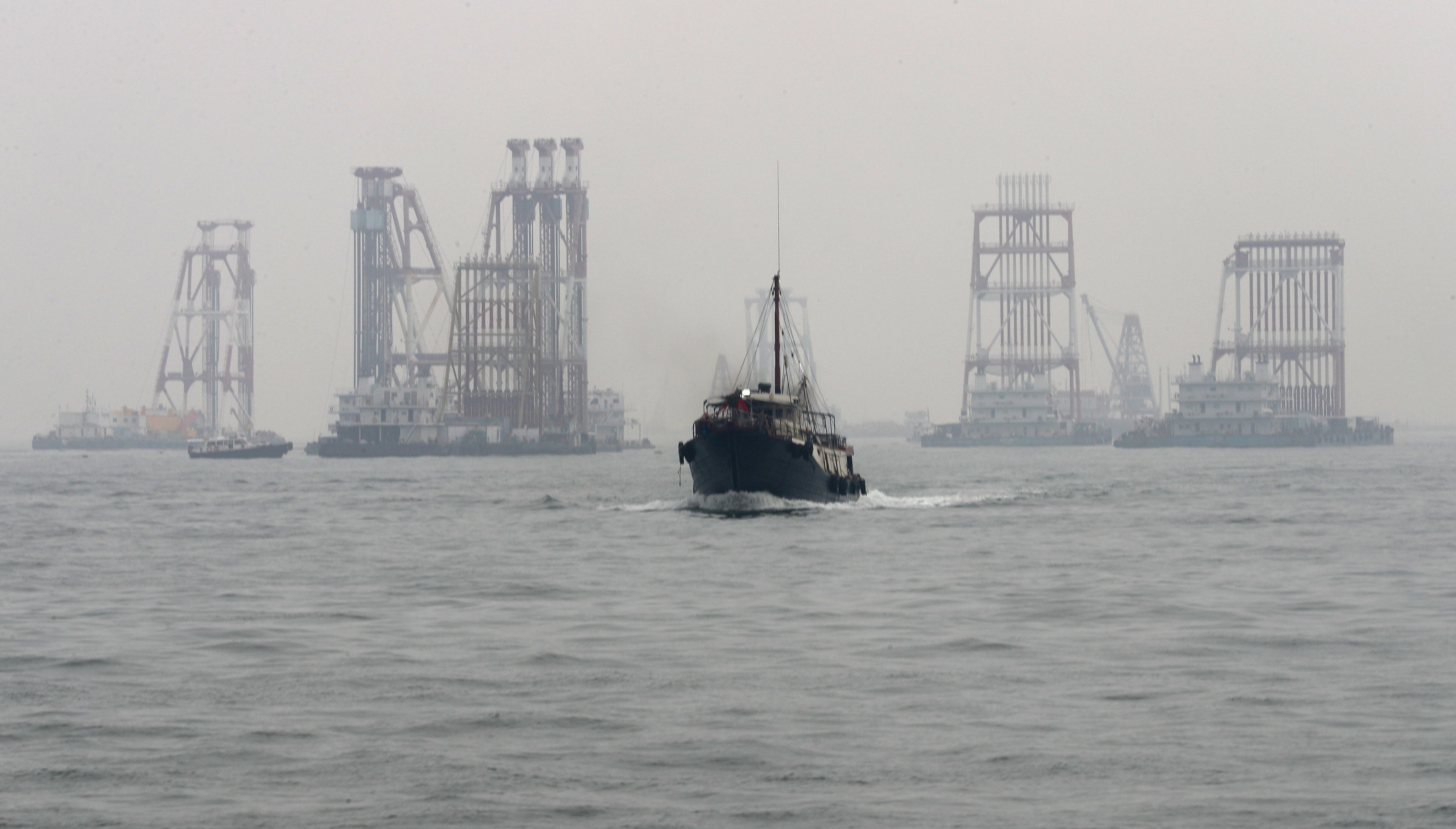 A boat heads away from construction work as part of the third runway at Hong Kong International Airport on August 20, 2018. Uncertainty over the future of the aviation industry and potential cost overruns raise questions about the need for the project. Photo: Nora Tam