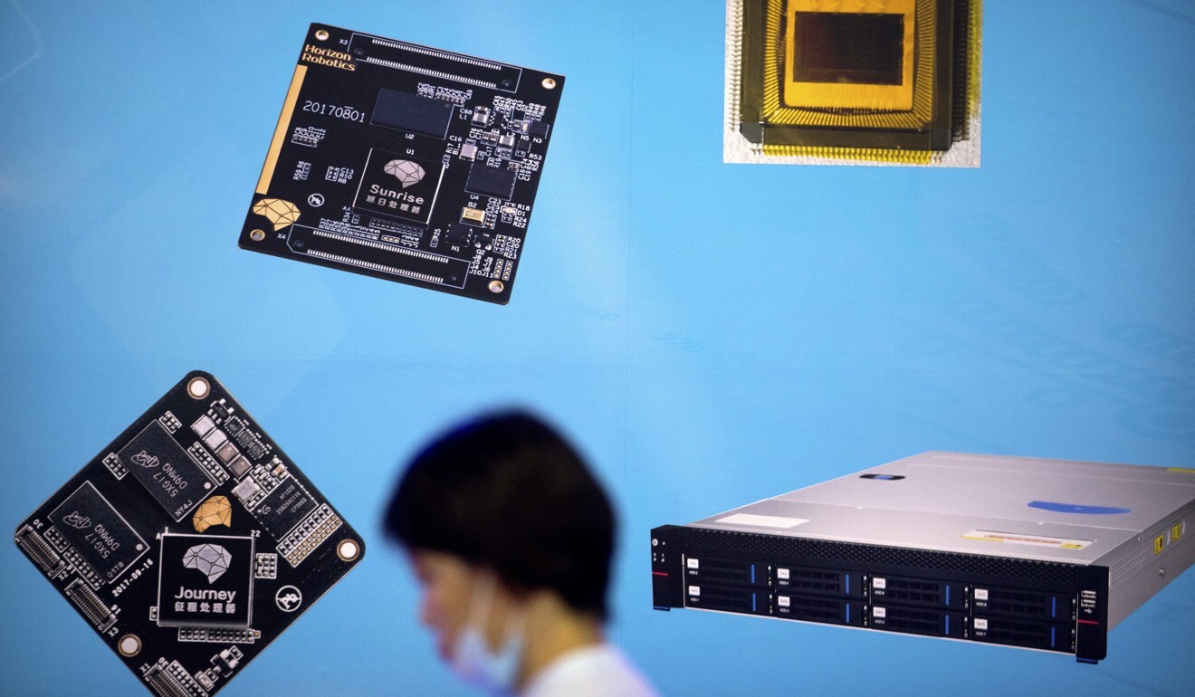 A visitor walks past a display showing microchips and circuit boards at a tech fair in Beijing in May 2018. Photo: AP