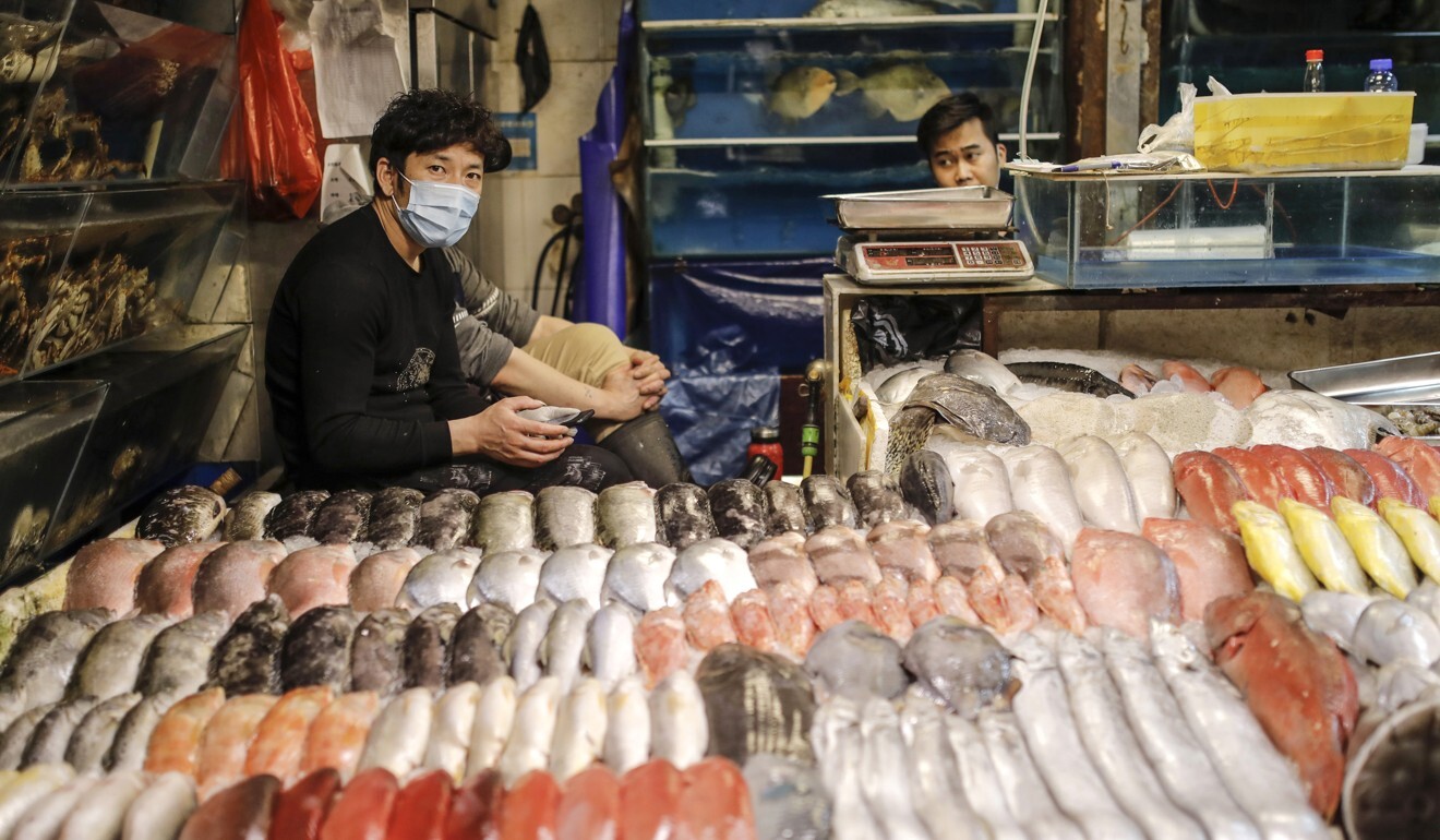 Seafood sellers wear protective face masks at a market in Beijing. Photo: EPA-EFE