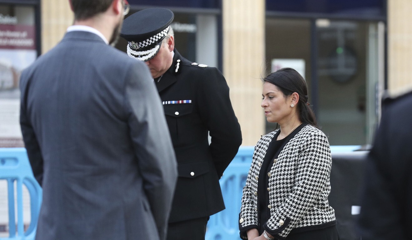 Chief Constable of Thames Valley Police, John Campbell stands next to Britain’s Home Secretary Priti Patel, as they wait to light a candles during a vigil in the town of Reading. Photo: PA via AP