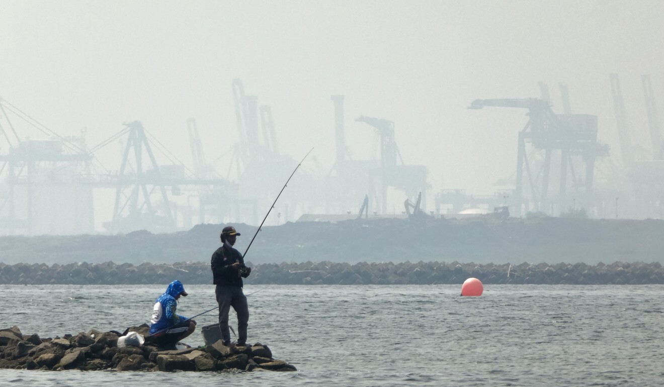 Anglers fish amid thick haze at a coastal area in Jakarta, Indonesia. Photo: AFP