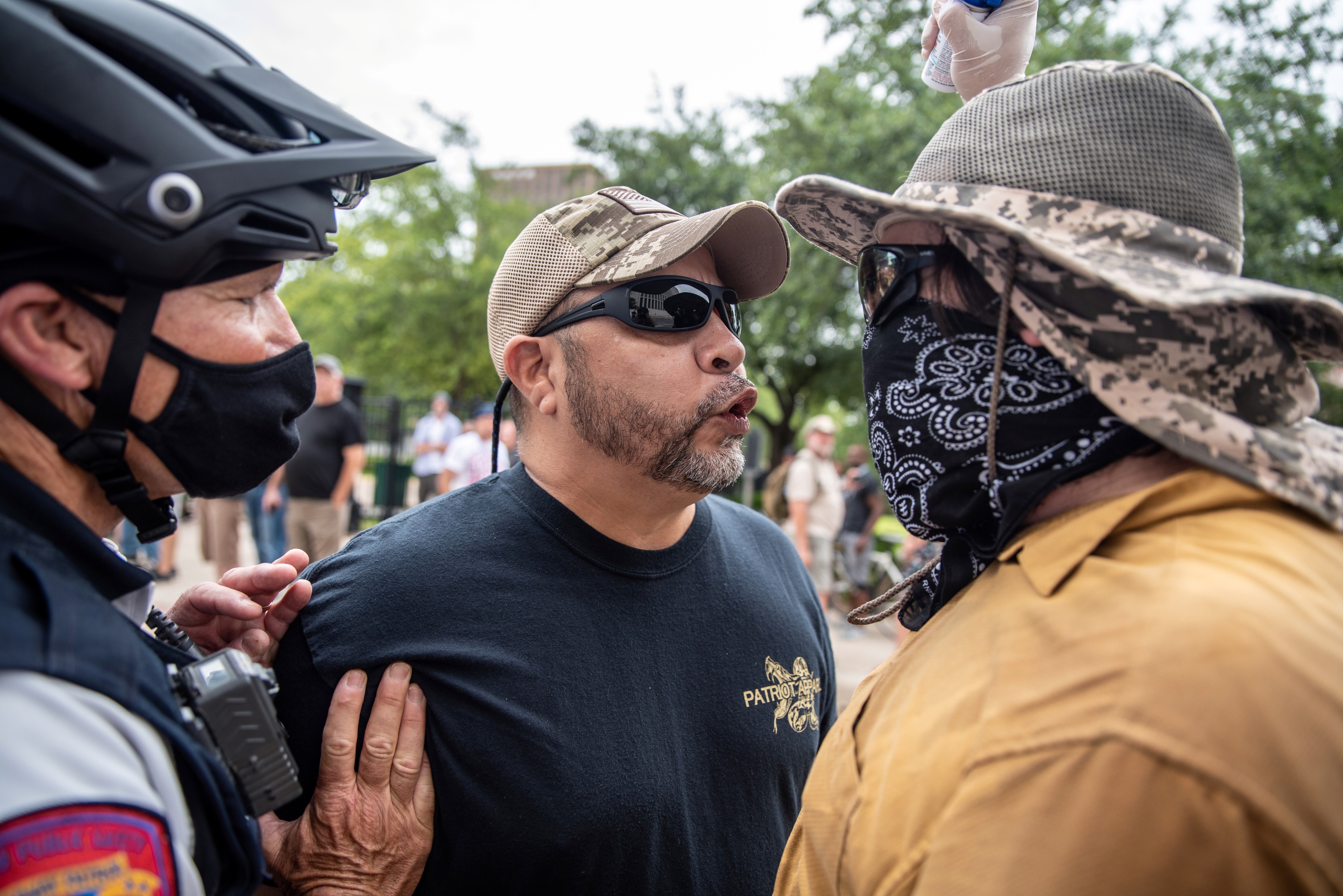 Two protesters are separated by a police officer at a protest in Austin, Texas, on Sunday against mandates to wear masks. Photo: Reuters