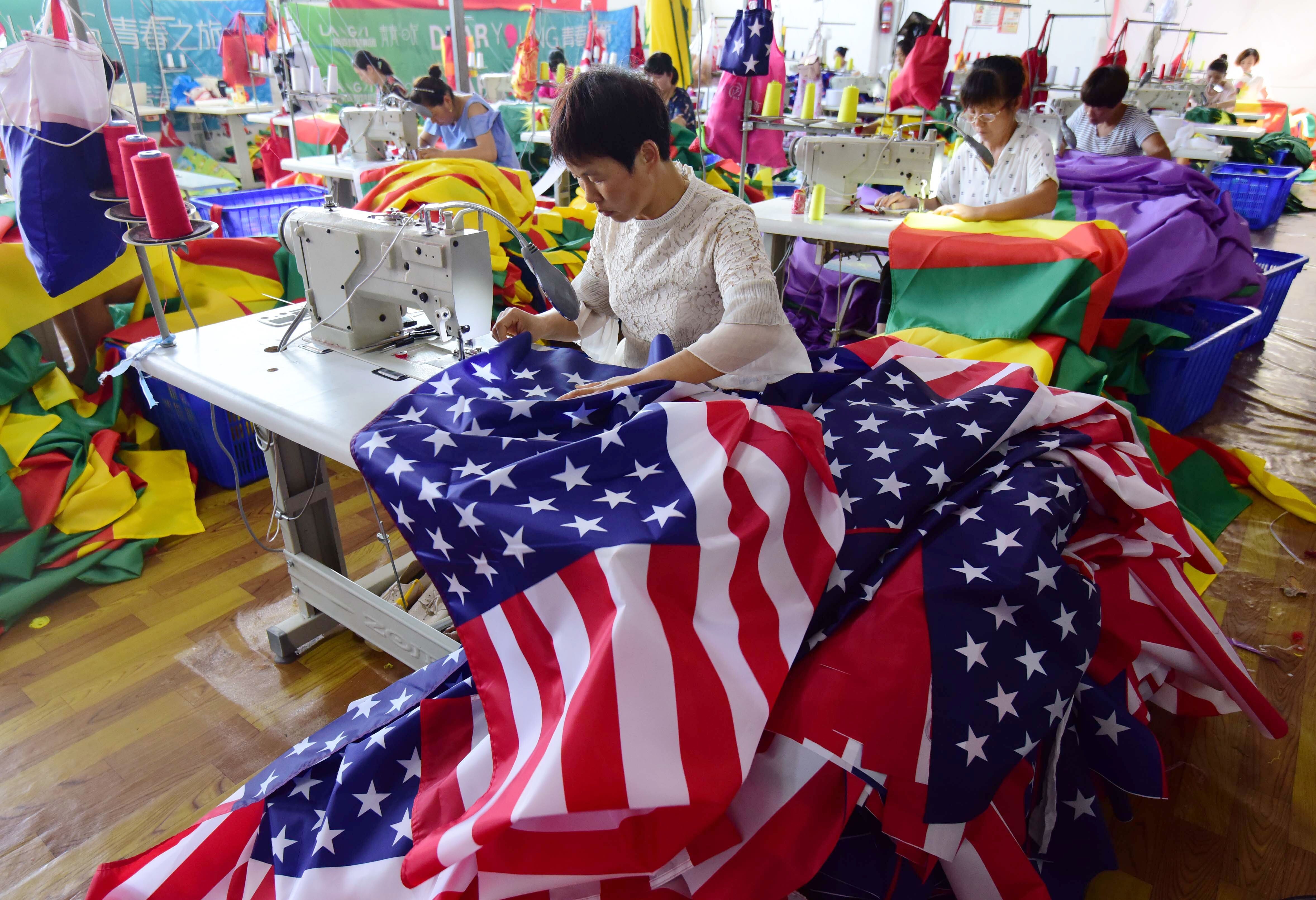 Chinese workers sew US and other flags at a factory in Fuyang, in China’s eastern Anhui province, in July 2018. China has increased trade with the rest of the world to offset the reduction of exports to the US. Photo: AFP