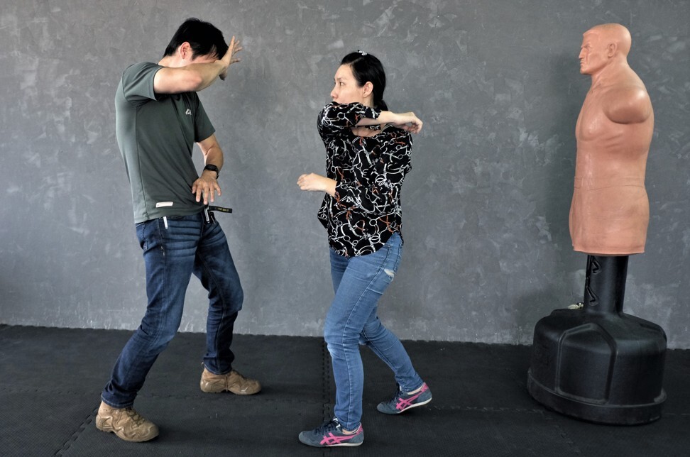 Pannarat Rattanasinchai (right) practises a self-defence technique with an instructor at a gym in Bangkok. Photo: Tibor Krausz