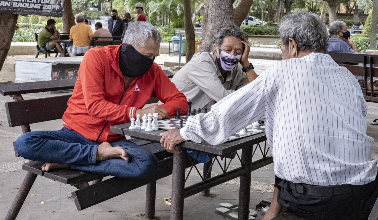 People wearing face masks play chess at a park in Denpasar, Bali, as Indonesia reported a new daily record in coronavirus cases. Photo: EPA-EFE