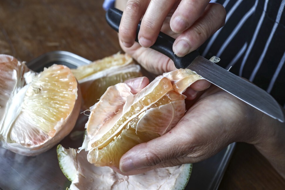 Use a sharp knife to peel the pomelo. Photo: SCMP / Jonathan Wong