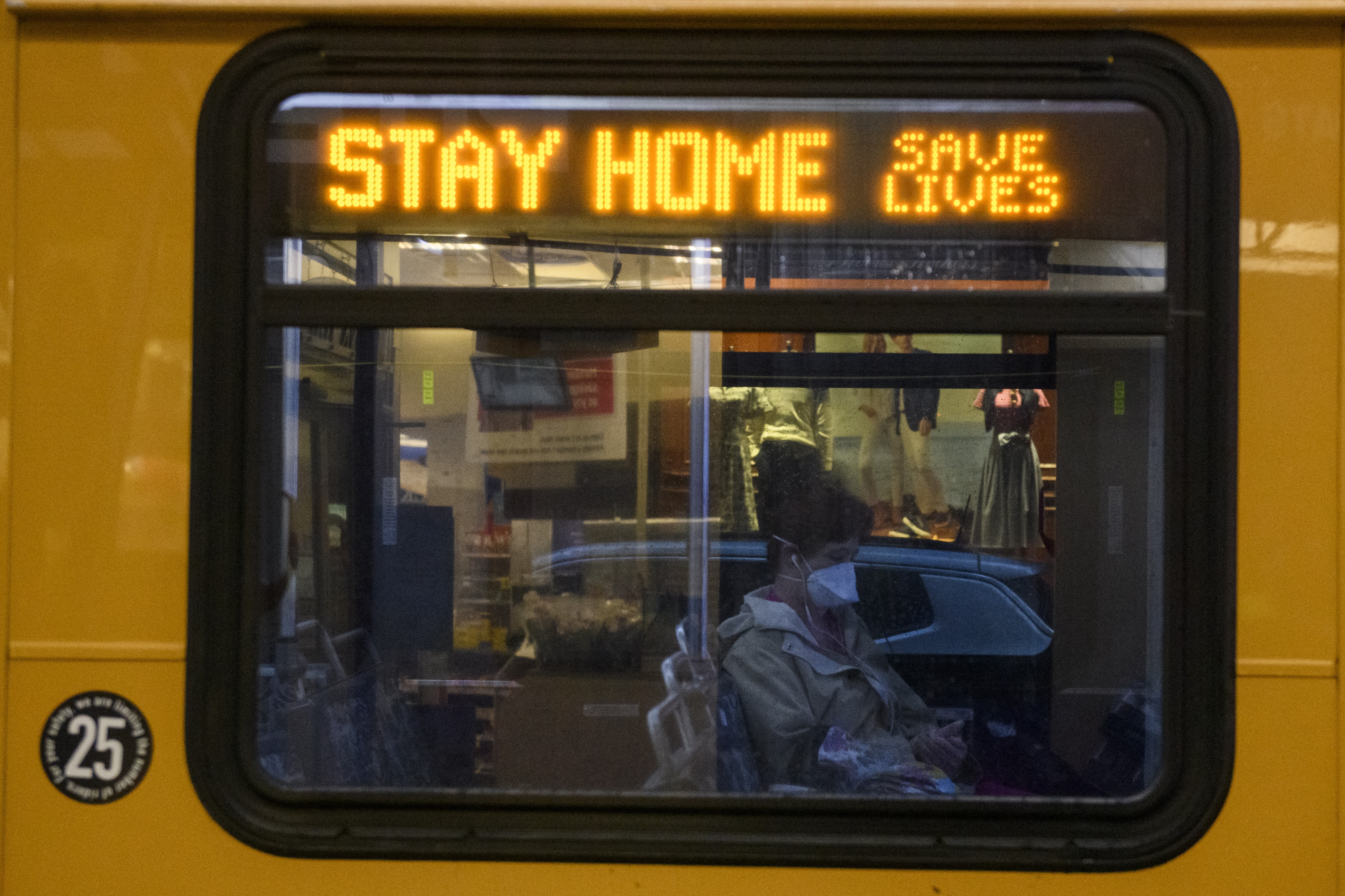 A commuter wearing a protective mask sits on a bus displaying an electronic sign that reads “Stay Home. Save Lives” in downtown Pittsburgh, Pennsylvania, US, on April 21. Photo: Bloomberg