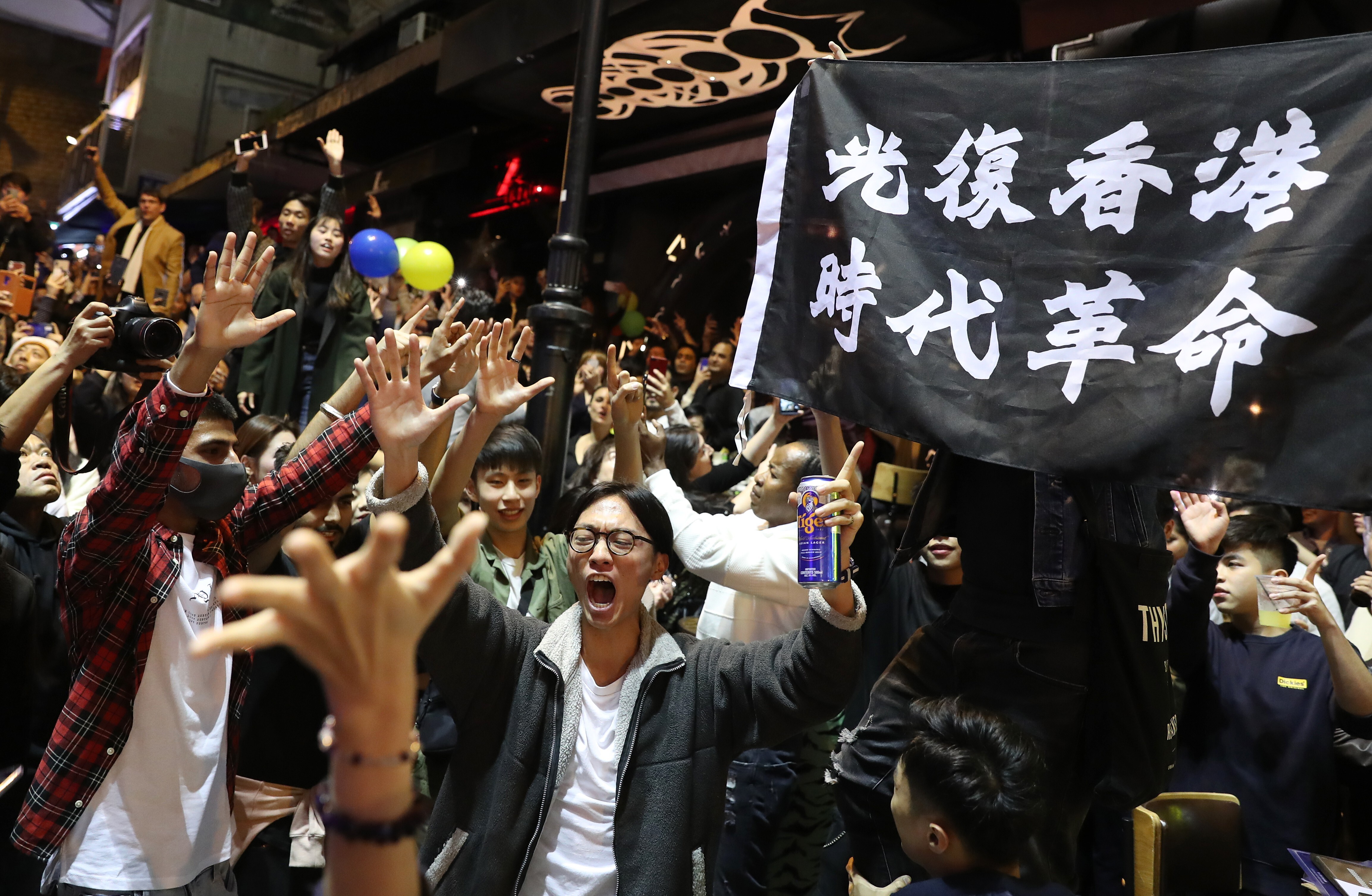 A banner bearing the slogan “Liberate Hong Kong; revolution of our time” is held aloft at a 2020 New Year’s party in Hong Kong’s Central district. Photo: Sam Tsang