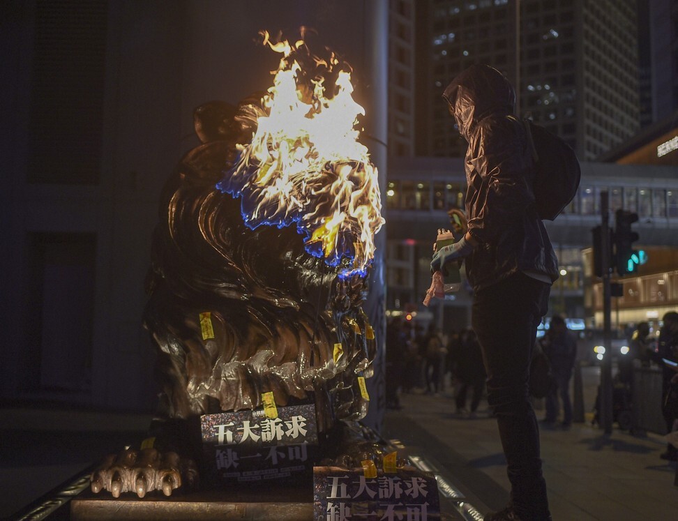 An arsonist setting one of HSBC’s iconic lion statues on fire after an anti-government protest in Hong Kong on January 1, 2020. Photo: AFP