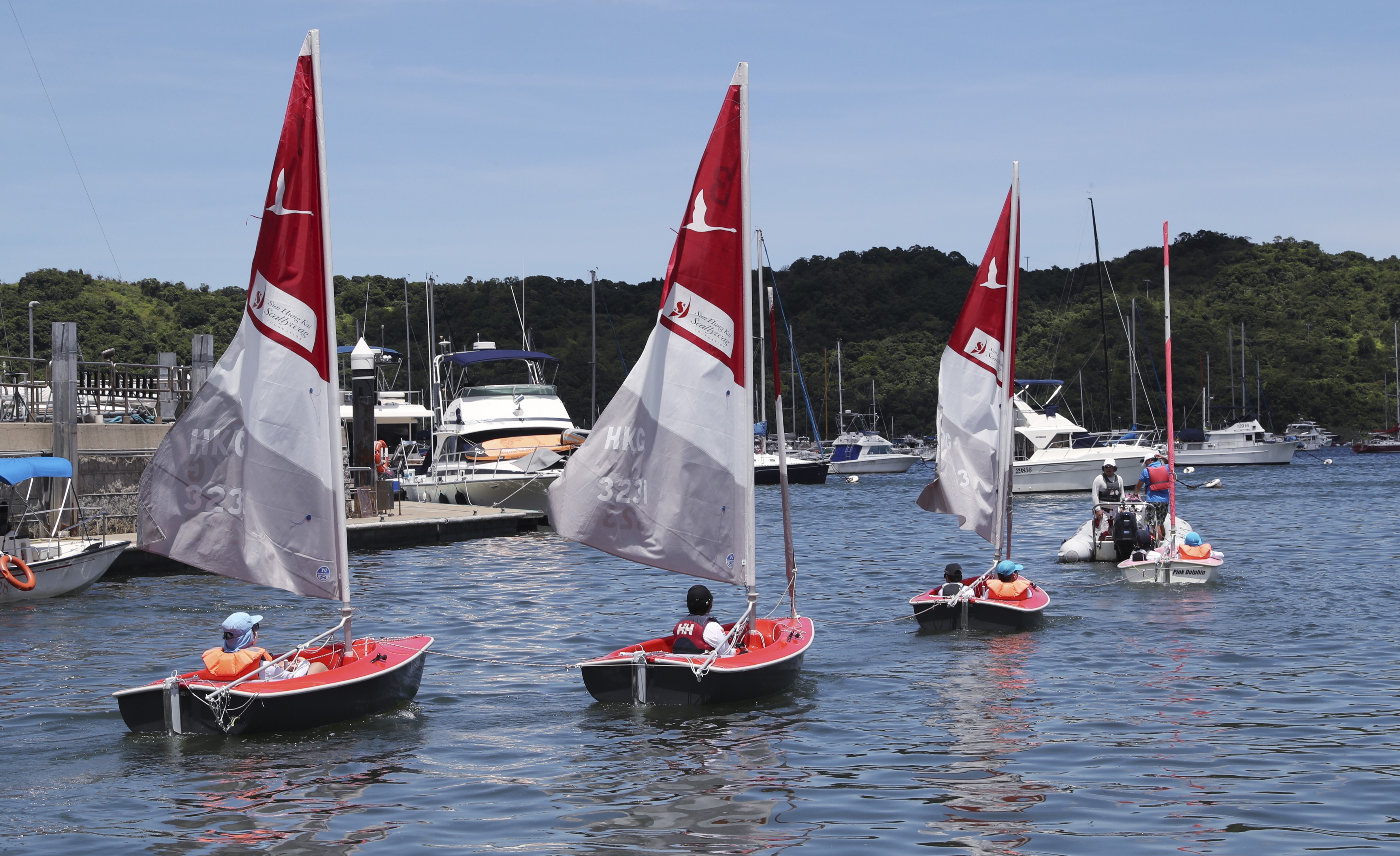 Kids head out to the water in their dinghies as part of the Sailability and Sun Hung Kai/Scallywag partnership. Photo: Edmond So