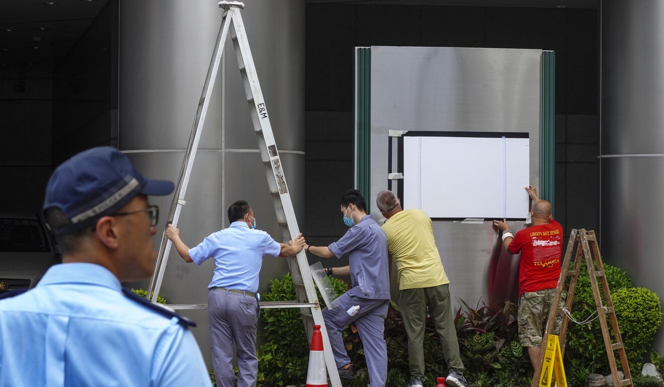 Workers outside the Metropark Causeway Bay hotel on Tuesday retrofit it for its new role as the home of Beijing’s national security office for Hong Kong. Photo: Sam Tsang