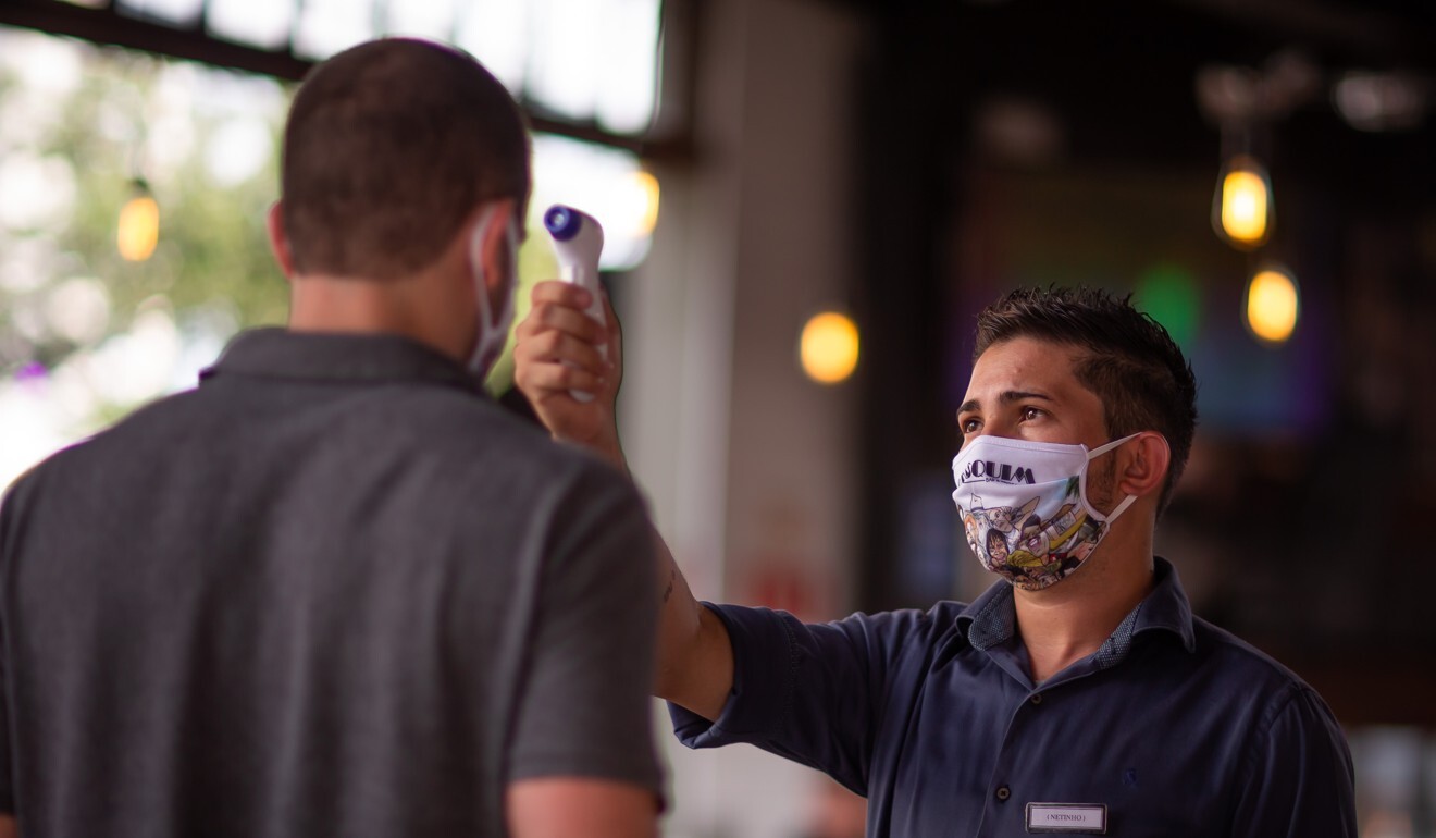 A customer gets his temperature checked at a restaurant in Sao Paulo, Brazil on Monday. The city was found to have a lower Covid-19 death rate than some parts of the US. Photo: Bloomberg