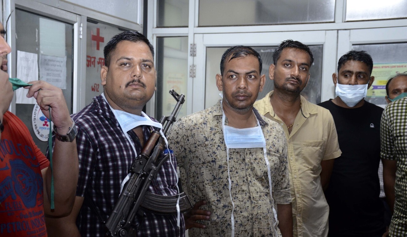Police officers stand guard at a hospital where the body of Vikas Dubey is being kept. Photo: AP