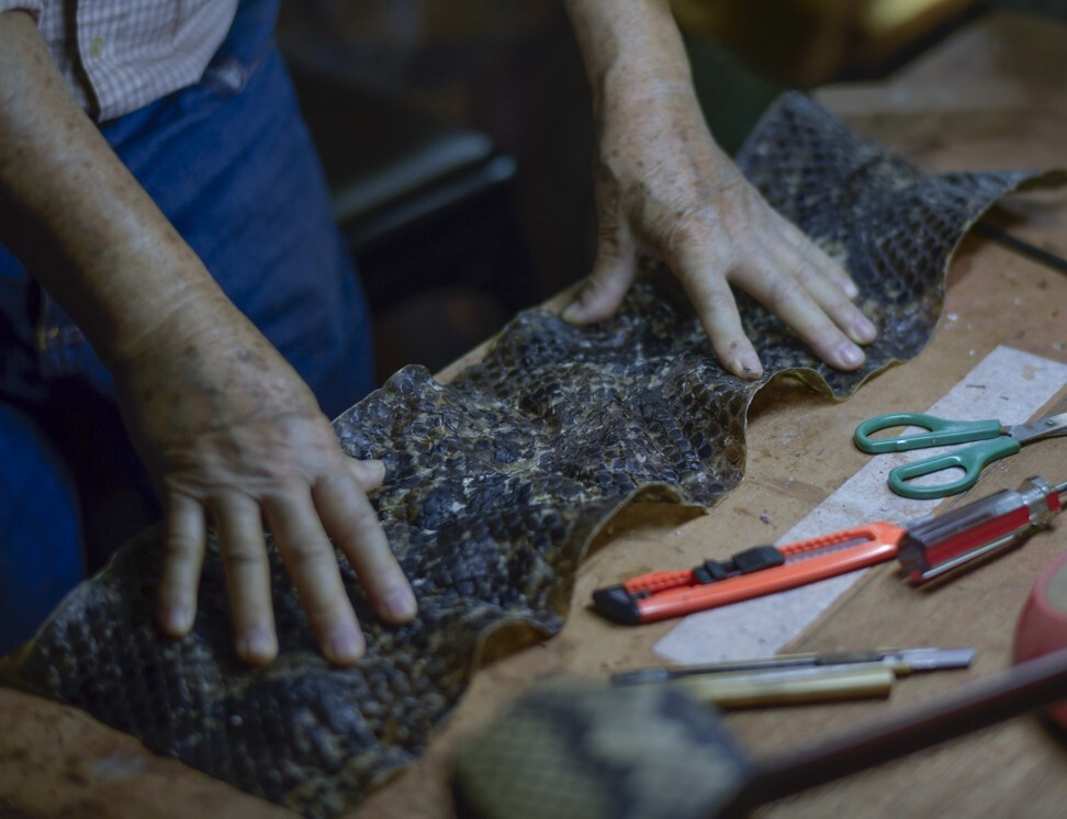Tong measures up snakeskin for one of his erhus. Photo: Warton Li