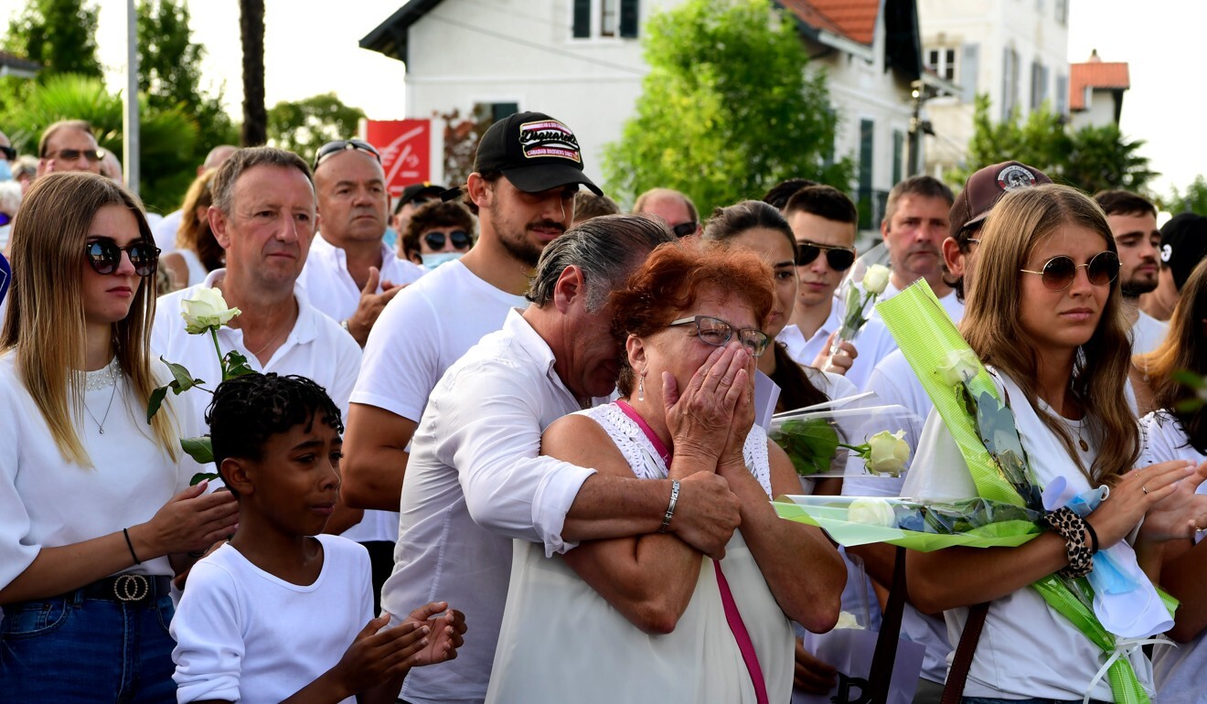 Parents of Veronique Monguillot, Philippe’s wife, react as they participate in a remembrance march for the bus drive. Photo: EPA