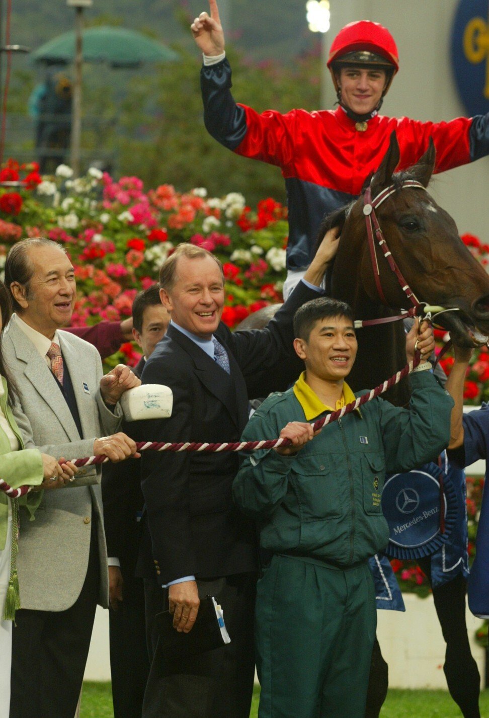 John Moore celebrates Viva Pataca’s win in the 2006 Hong Kong Derby with jockey Christophe Soumillon and owner Stanley Ho (left).