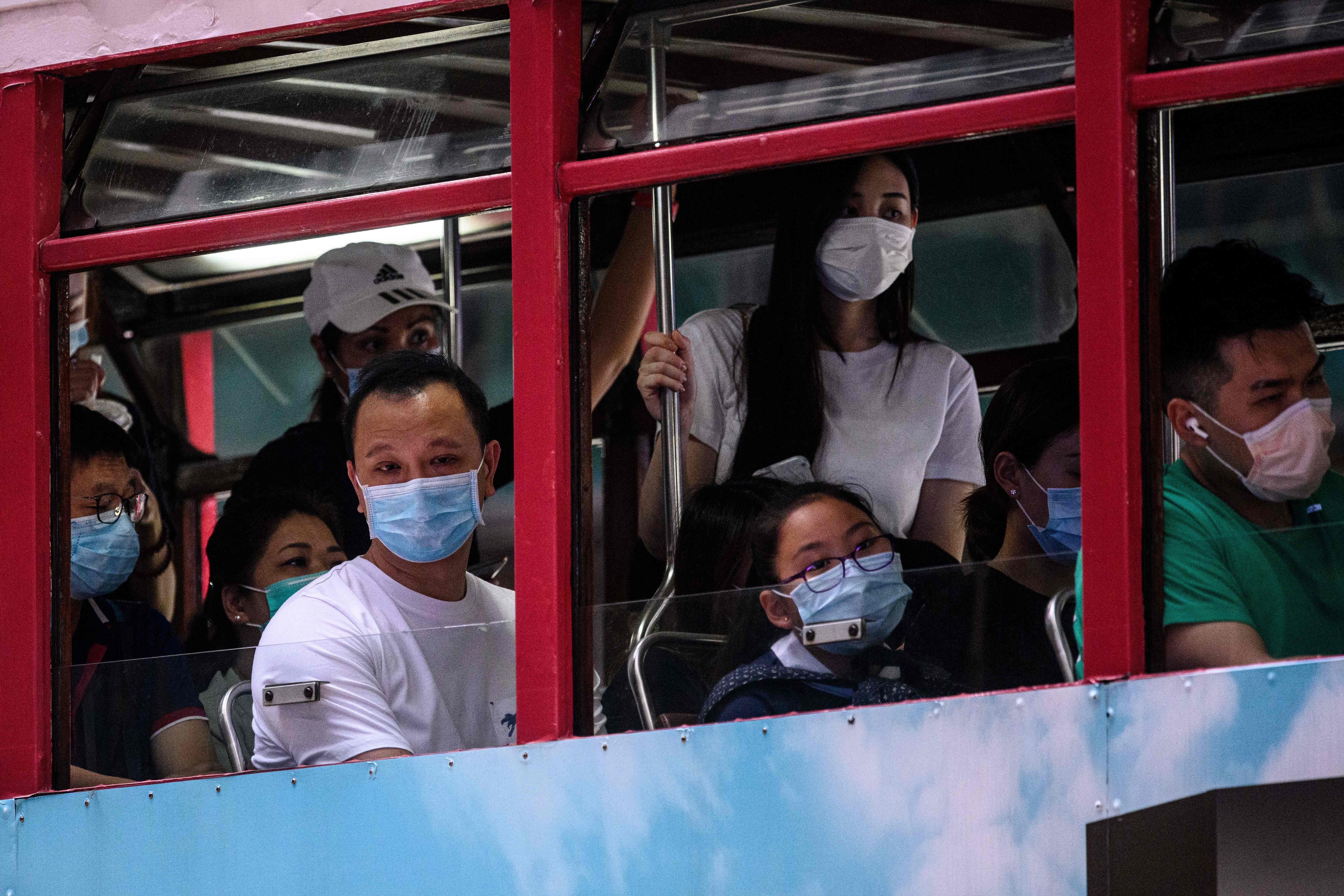 Commuters wear face masks as they travel on the top deck of a tram in Hong Kong on July 10. The emergence of a third wave of Covid-19 infections has led to renewed calls for social distancing and working from home. Photo: AFP