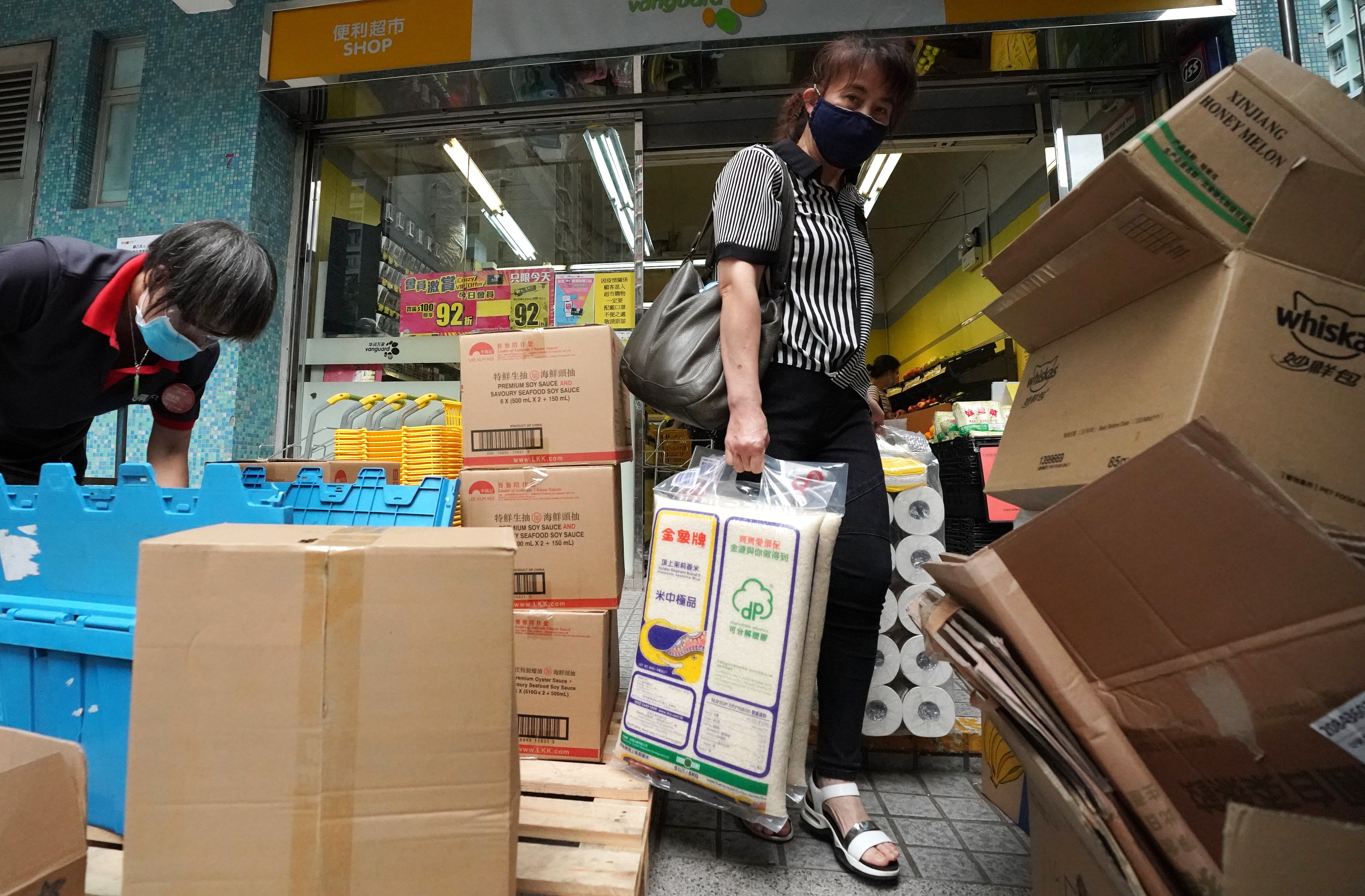 A woman walks out of a supermarket in Tsz Wan Shan on Tuesday with bags of rice and toilet rolls. Photo: Felix Wong