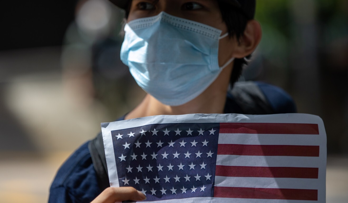 A protester displays the US flag outside the US Consulate General in Hong Kong to celebrate the Fourth of July. In response to China’s moves on Hong Kong, President Trump on Tuesday signed the Hong Kong Autonomy Act into law and an executive order removing the city’s special trade status. Photo: EPA-EFE