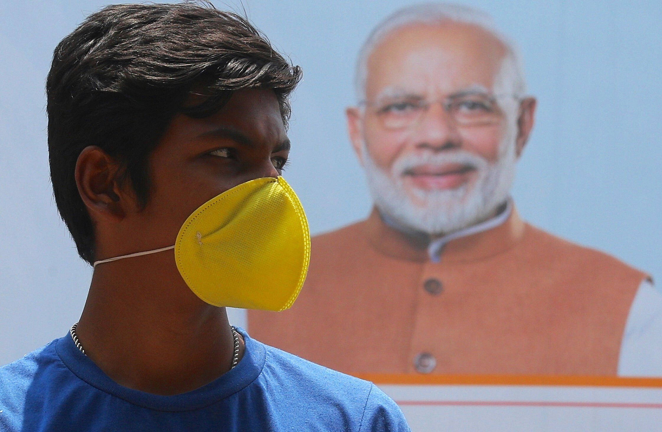 An Indian youth in front of a poster of Prime Minister Narendra Modi during a lockdown in Bangalore on May 1. Although the country's initial 21-day lockdown was extended, case numbers have continued to climb. Photo: EPA-EFE