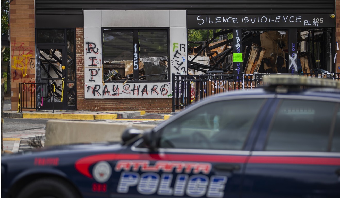 An Atlanta Police Department vehicle is seen in front the burned down Wendy's restaurant as it is cleared of protesters and their belongings. Photo: EPA-EFE