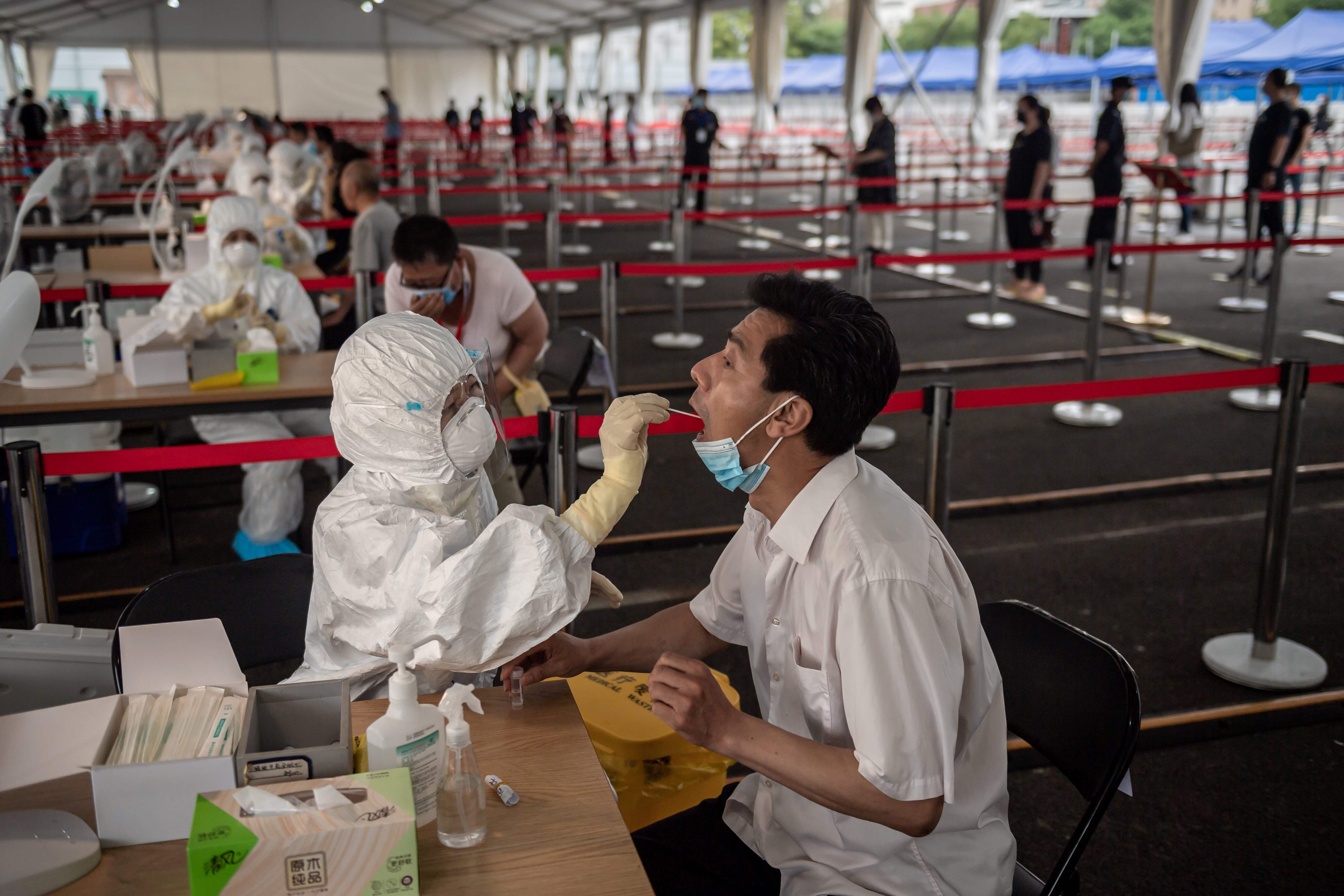 A health worker takes a swab test on a man during mass testing for Covid-19 at the Jinrong Street testing site in Beijing on June 24. Hong Kong could boost its testing capacity by tapping into excess capacity on the mainland. Photo: AFP