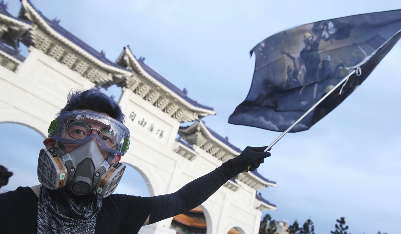 A Hong Kong protester in Taiwan waves a flag marking the first anniversary of a mass rally in Hong Kong against a since-withdrawn extradition bill. Photo: AFP