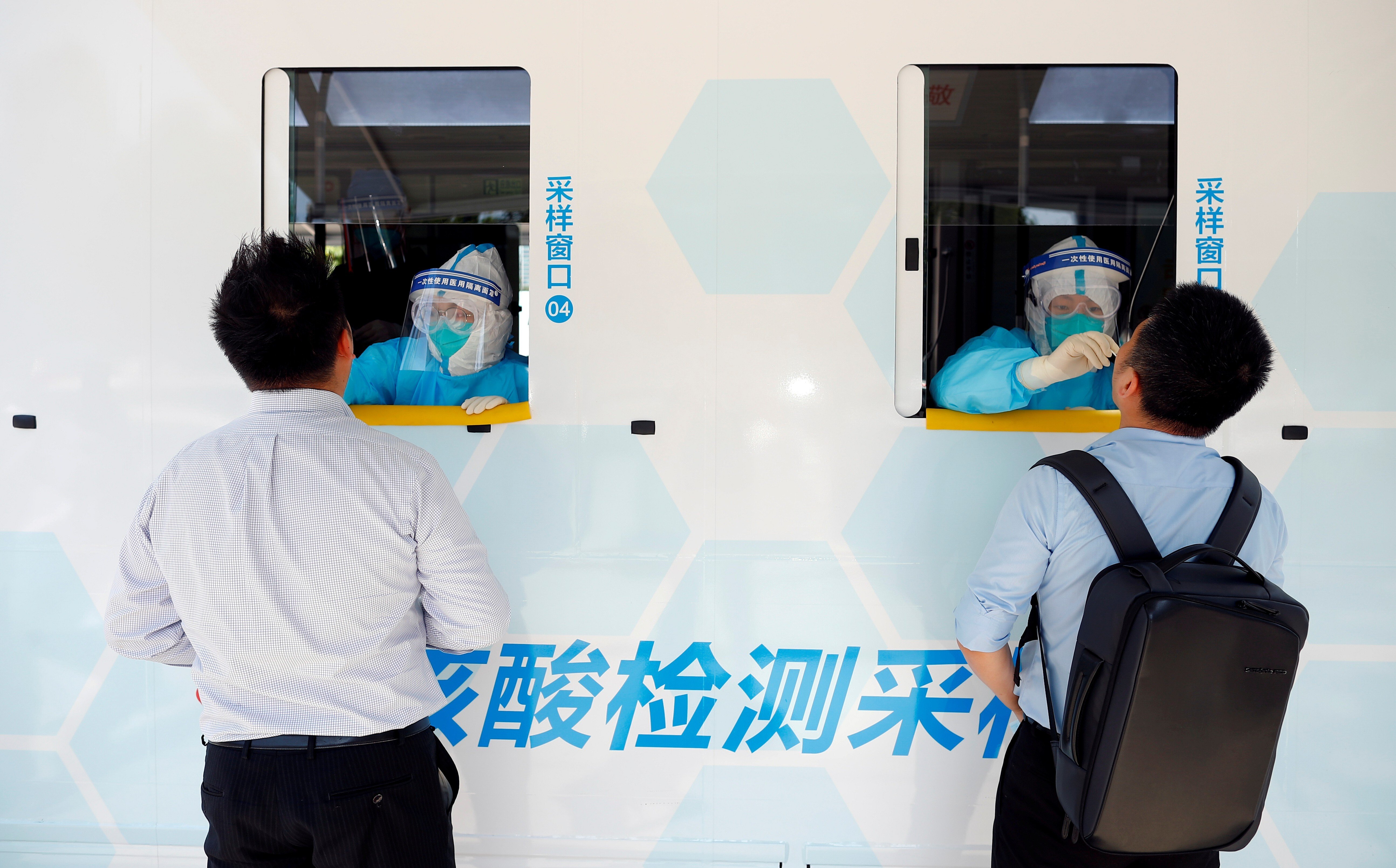 Two people are tested at the windows of a testing vehicle in Beijing on June 30. The success of group testing methods in containing Covid-19 outbreaks in Wuhan and Beijing suggest it might be a useful approach for Hong Kong given the city’s constrained testing capacity. Photo: Reuters