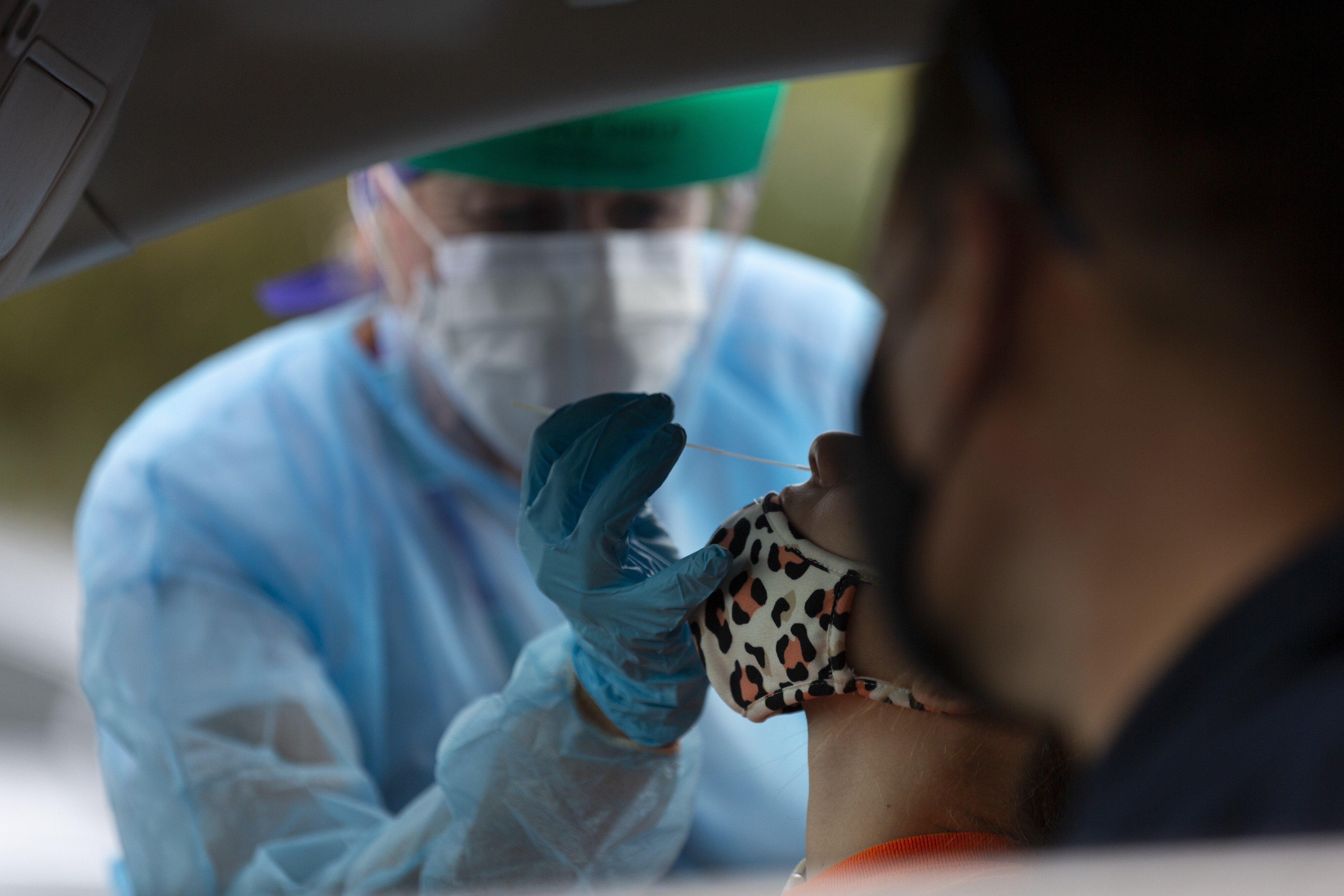 A healthcare worker wearing personal protective equipment (PPE) administers a test at an El Rio Health Covid-19 drive-thru testing site in Tucson, Arizona. Photo: Bloomberg